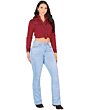 Full-body shot of a woman in a western outfit, featuring light blue boot cut jeans and a cropped embroidered blouse.