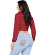 Back view of a woman wearing light blue boot cut jeans, highlighting detailed embroidered back pockets.