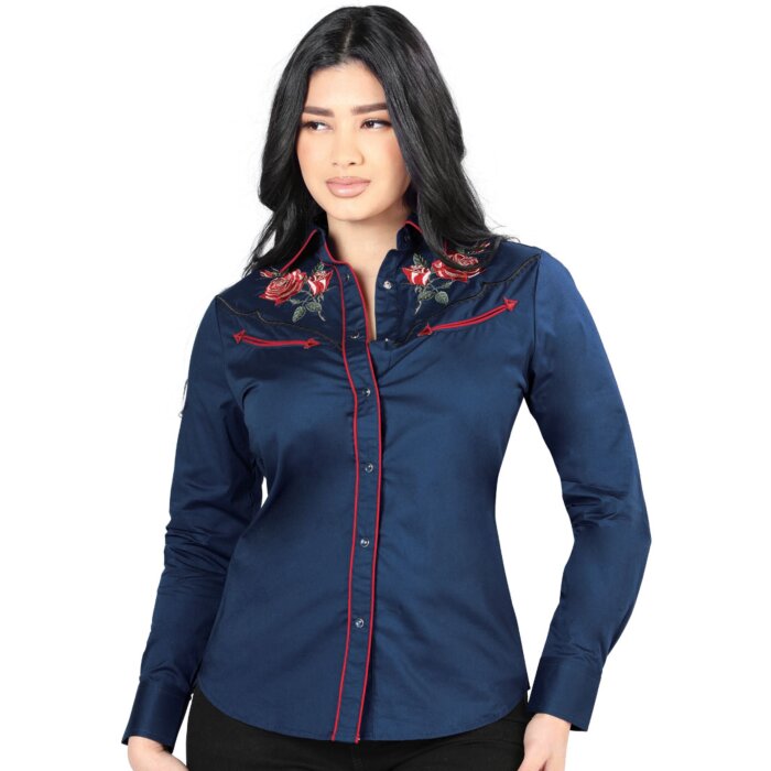 Mujer de pelo negro luciendo blusa vaquera color azul con vivos rojos y bordado de rosas rojas cerca de los hombros.