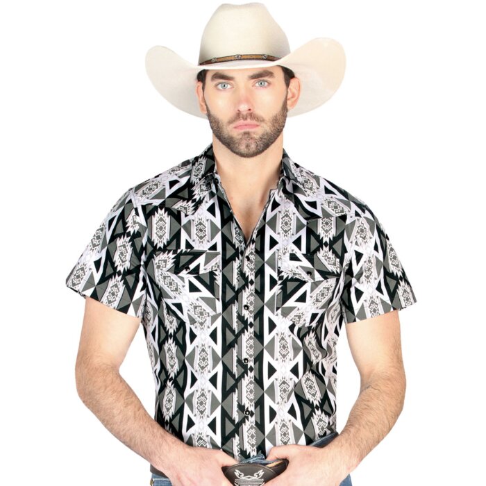 Hombre usando una camisa vaquera gris de manga corta con patrones geométricos llamativos en negro, blanco y gris, con botones de presión para un look cowboy moderno.