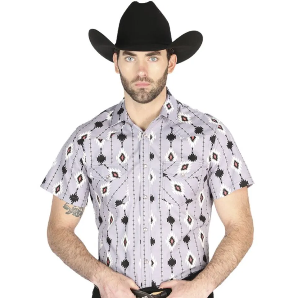 Hombre usando una camisa vaquera de manga corta en color lila con patrones tribales y cierre de botones de presión, ideal para días cálidos.