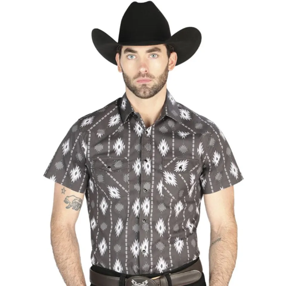 Hombre usando una camisa vaquera negra de manga corta con diseño estilo ikat y cierre de botones de presión.