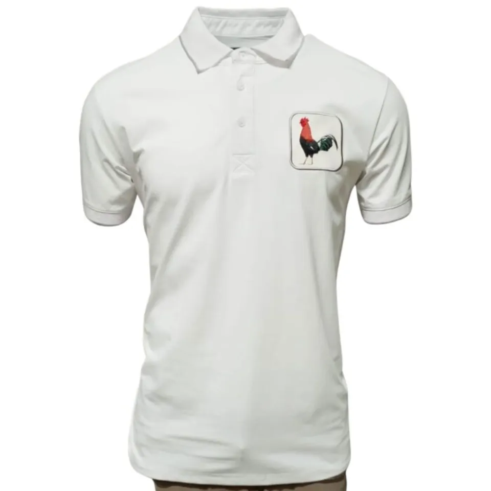 Camisa polo blanca para caballero con un distintivo bordado de gallo, confeccionada en una mezcla transpirable de algodón y poliéster por Montero.