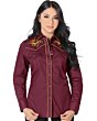 Mujer de pelo negro luciendo blusa vaquera color vino con bordado de girasoles y vivos rojos, botonadura de broche.