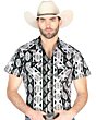 Hombre usando una camisa vaquera gris de manga corta con patrones geométricos llamativos en negro, blanco y gris, con botones de presión para un look cowboy moderno.