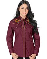 Mujer de pelo negro luciendo blusa vaquera color vino con bordado de girasoles y vivos rojos, botonadura de broche.
